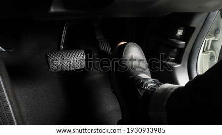 Accelerator and breaking pedal in a car. Close up the foot pressing foot pedal of a car to drive ahead. Driver driving the car by pushing accelerator pedals of the car. inside vehicle. 
 Royalty-Free Stock Photo #1930933985