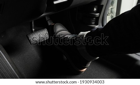 Accelerator and breaking pedal in a car. Close up the foot pressing foot pedal of a car to drive ahead. Driver driving the car by pushing accelerator pedals of the car. inside vehicle. 
 Royalty-Free Stock Photo #1930934003