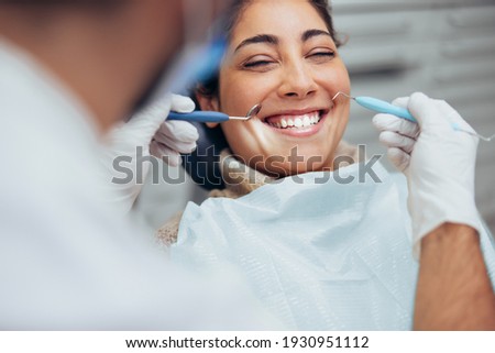 Over the shoulder view of a dentist examining a patients teeth in dental clinic. Female having her teeth examined by a dentist. Royalty-Free Stock Photo #1930951112