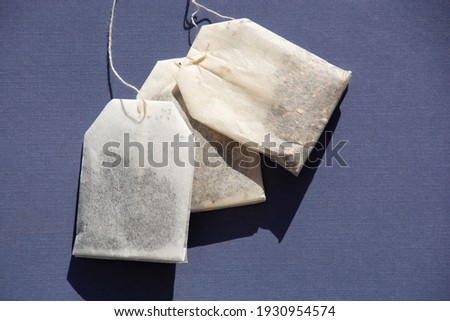 lying paper teabags on a heap filled with different aromatic tea