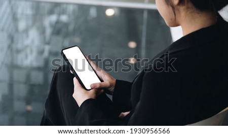 Businesswoman holding smart phone with white blank screen. For Graphic display montage