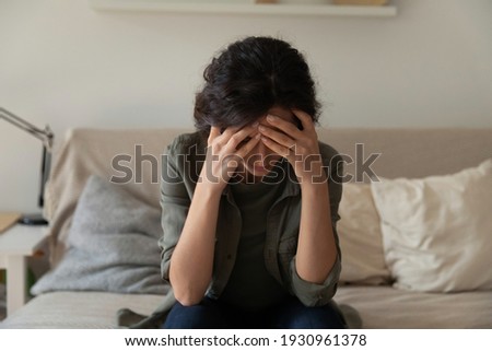 It hurts to even think about. Frustrated depressed millennial woman sit on couch alone hug head hide face in palms. Stressed young female drug alcohol addiction victim suffer of mental problem shame Royalty-Free Stock Photo #1930961378