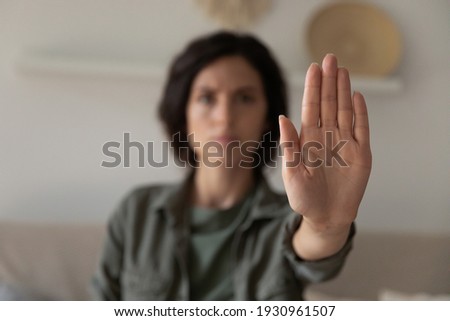 I said stop it. Blurred portrait of young lady looking at camera extending hand forward saying no enough to abuse family violence abortion. Focus on female palm close up raised in prohibiting gesture Royalty-Free Stock Photo #1930961507