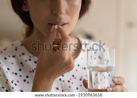 Taking meds. Close up cropped shot of young lady hold glass of water prepare to swallow pill. Sick woman drink painkiller antidepressant fat burner supplement antibiotics use emergency contraception Royalty-Free Stock Photo #1930963658