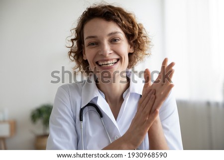 Headshot portrait of smiling young Caucasian female doctor look at camera talk on video call with patient. Happy woman GP have online webcam consultation with hospital client on computer. Royalty-Free Stock Photo #1930968590