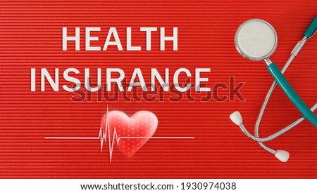 Health Insurance concept with stethoscope and heart shape on a red background