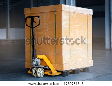 Heavy Package Box Wrapped Plastic Film on Pallet with Hand pallet Truck. Cargo Shipment. Shipping Warehouse. Royalty-Free Stock Photo #1930981343