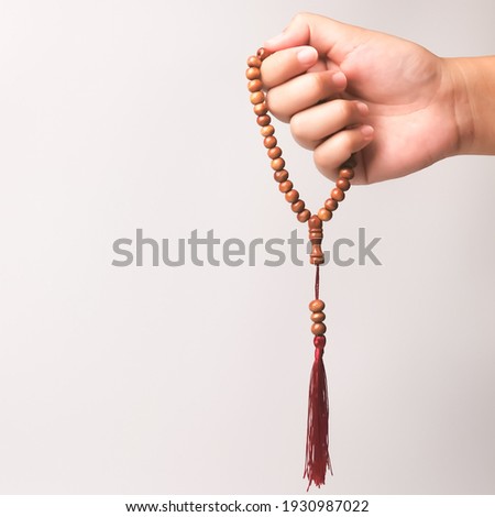 Selective focus image hand of muslim woman holding a prayer beads isolated on white background with copy space. Royalty-Free Stock Photo #1930987022