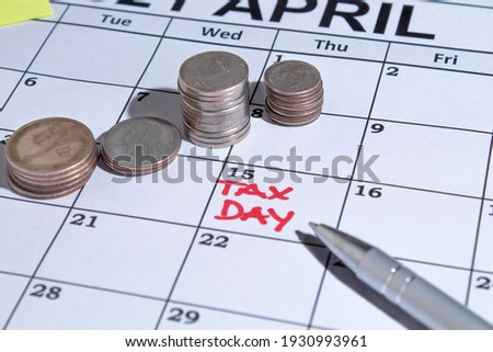 Tax day image with an april calendar a pen a calculator i coins for tax time