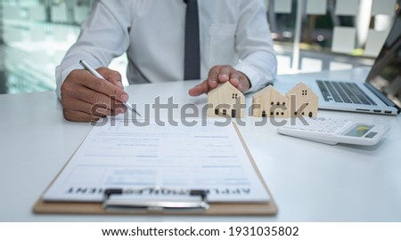 Real estate agent and customer signing contract to buy house, insurance or loan real estate.rent a house,get insurance or loan real estate or property. Royalty-Free Stock Photo #1931035802