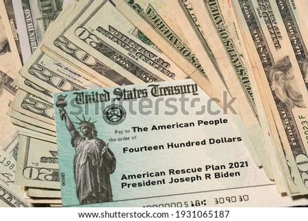 Stack of 20 dollar bills with US Treasury illustrative check to illustrate American Rescue Plan Act of 2021 payment on cash background Royalty-Free Stock Photo #1931065187