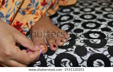 Washing varnish on nails. A pedicure treatment on the woman's feet performing by self at home. Washes the nail polish with a cotton swab.