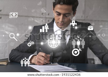 Businessman in office signs contract and business hologram. Double exposure. Formal wear. Concept of study market and analysis.