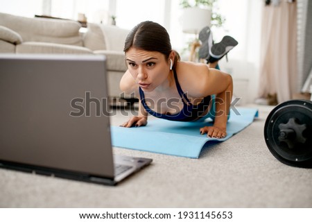 Smiling girl sits on floor, online fit training