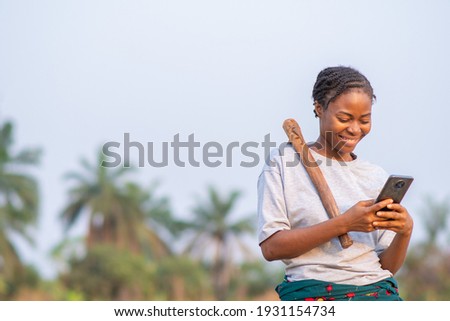female african farmer using her phone Royalty-Free Stock Photo #1931154734