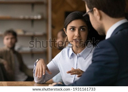 Close up Indian businesswoman discussing project with Caucasian colleague, brainstorming, sharing ideas, diverse coworkers working together, hr manager listening to candidate at job interview Royalty-Free Stock Photo #1931161733