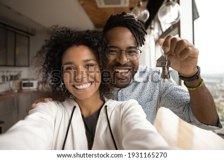 Head shot portrait overjoyed African American married couple showing keys, happy wife and husband, homeowners or tenants making selfie, purchased first dwelling, new apartment, mortgage concept Royalty-Free Stock Photo #1931165270