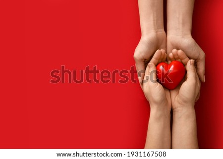 Hands with red heart on color background Royalty-Free Stock Photo #1931167508