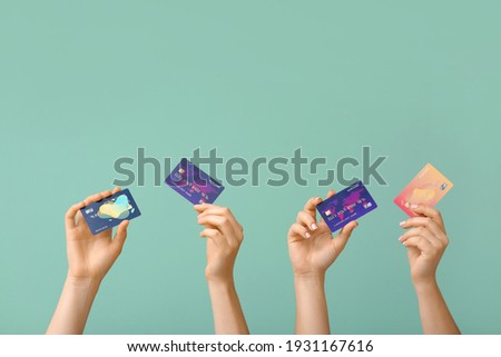 Female hands with credit cards on color background Royalty-Free Stock Photo #1931167616