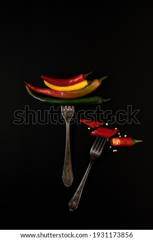 Chilli peppers of different colors, impaled on a vintage fork