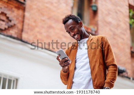 Handsome African man using mobile cell phone - technology concept