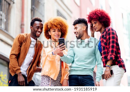 Four young people together look at a mobile cell phone gesturing - freestyle concept