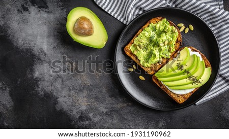 Avocado Toast for breakfast or lunch with rye bread, pumpkin seeds. Vegetarian food. Clean eating. Top view. Copy space. Royalty-Free Stock Photo #1931190962