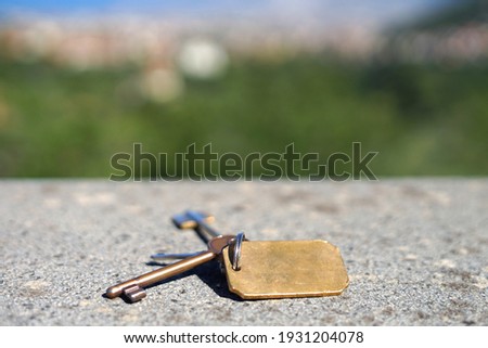 Vintage keys from castle, chateau or historic building put on stony terrace with blurred aerial view, real estate concept