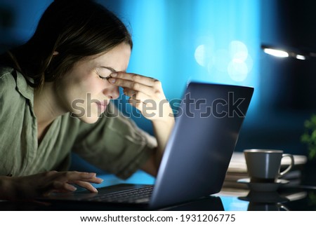 Fatigued woman suffering eyestrain using laptop complaining at night at home Royalty-Free Stock Photo #1931206775