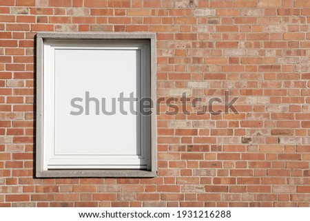 Brick wall with frame, facade with red and even surface, white window with space for text 