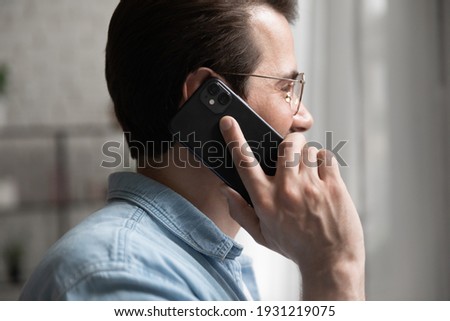 I am listening. Cropped side shot of skilled male professional expert consulting customer by phone hold device to ear. Confident young man client support manager answering call speak talk help caller Royalty-Free Stock Photo #1931219075