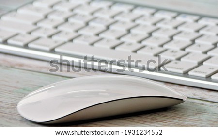 keyboard with a computer mouse on a wooden table