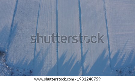  heavily snowy field. snow winter landscape view shot of rolling hills with plough lines and green trees - Aerial Flight 