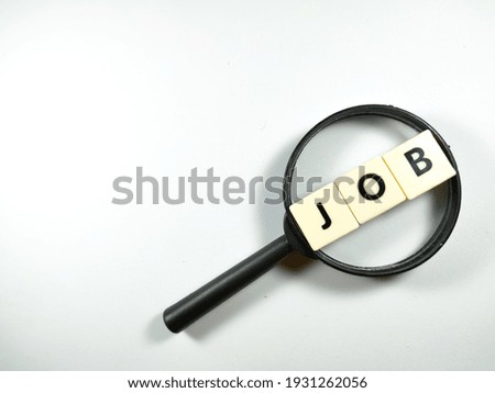 Selective focus.Magnifying glass and scrabble letters with text JOB on white background.