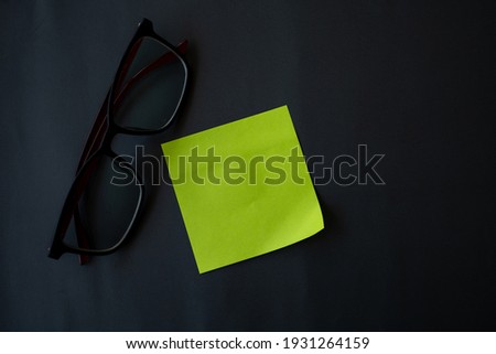 Note paper and glasses on a gray-black background, Reminder paper
