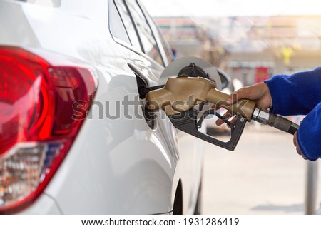 Pumping gasoline fuel in car at gas station.concept Travel and transportation. Royalty-Free Stock Photo #1931286419