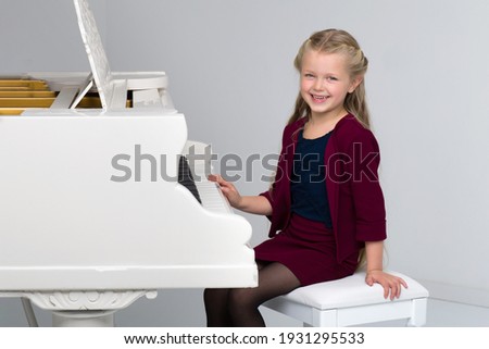 Smiling girl playing grand piano