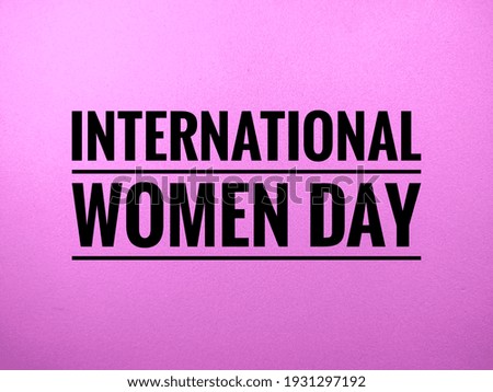 Selective focus.Word INTERNATIONAL WOMEN DAY on pink background.Positive saying for cards,motivational posters and smartphone wallpaper .