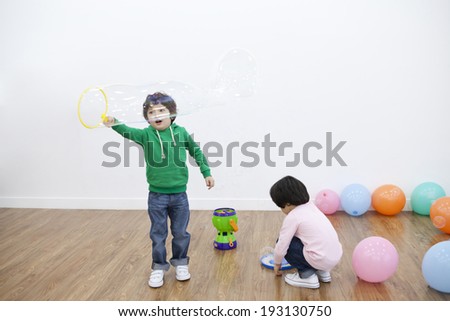 Cute Korean kids playing with bubble machine