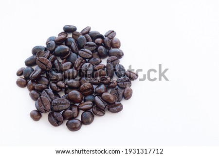 Close up pile of coffee beans roasted isolated on white background with copyspace for put text or logo.