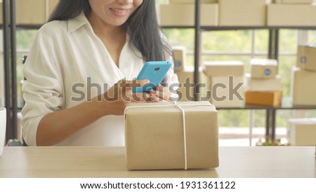 Asian business woman taking photo to send to customer. Postal parcel packaging box delivery, working from home, selling products online business. Shipping service. People lifestyle. SME ecommerce