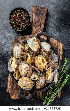 Cooked Clams vongole in a pan. Black background. Top view. Royalty-Free Stock Photo #1931373725