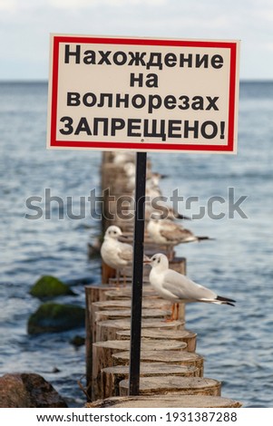 Warning sign at sea in Russian. Translation: it is forbidden to walk on breakwaters