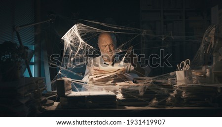 Corporate businessman searching for paperwork in an abandoned office: failure, financial crisis and outdated business concept Royalty-Free Stock Photo #1931419907