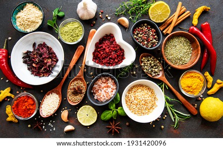 Various spices in a bowls on black concrete background. Top view copy space. Royalty-Free Stock Photo #1931420096