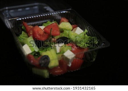 Greek Salad High Res,Fresh greek salad with tomato, cucumber, bel pepper , olives and feta cheese on black plate, top view, dark background