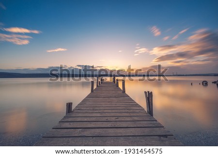 Old wooden dock at the lake, sunset shot Royalty-Free Stock Photo #1931454575