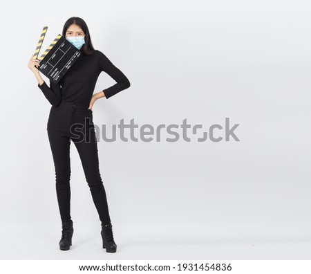 Asian woman wear face mask or medical mask and hand's hold black clapper board or movie slate use in video production ,film, cinema industry on white background.