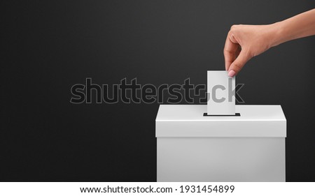 female or women Voter Holds Envelope In her  Hand Above Vote Ballot for casting vote on black background Royalty-Free Stock Photo #1931454899
