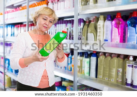 Female holding goods for cleaning house in the household chemical shop... Royalty-Free Stock Photo #1931460350
